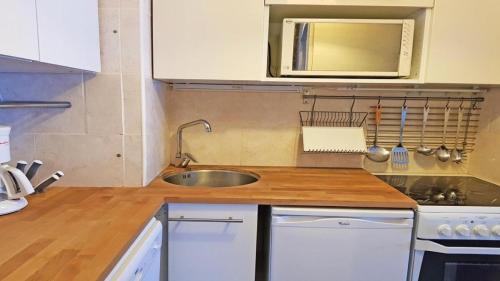 une cuisine avec un évier et un micro-ondes dans l'établissement Résidence Cortina 2 - C2616 - APPT T2 CABINE - 6 PERSONNES, 1 CHAMBRE EN CENTRE STATION MAE-8884, à Les Prés