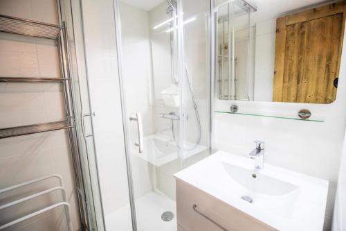 une salle de bain blanche avec un lavabo et une douche dans l'établissement Résidence Les Arolles - LES AROLLES - AR31A MAE-3158, à Villarodin-Bourget