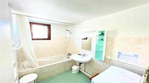 a bathroom with a sink and a tub and a toilet at Résidence Les Soldanelles - Appartements pour 6 Personnes 134 in Puy-Saint-Vincent