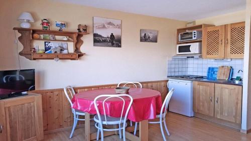 une cuisine avec une table et des chaises dans une cuisine dans l'établissement Résidence Pendine 2 - P2303 - Grand studio - 4 personnes - Centre de station MAE-8974, à Les Prés