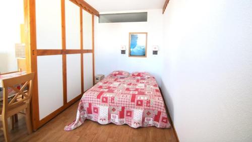 una camera da letto con un letto con copriletto rosa di Résidence Parc Aux Etoiles - C212PAE - APPARTEMENT 2 CHAMBRES AVEC BALCON MAE-9024 a Narreyroux