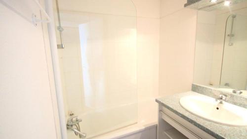 un bagno bianco con lavandino e doccia di Résidence Parc Aux Etoiles - C212PAE - APPARTEMENT 2 CHAMBRES AVEC BALCON MAE-9024 a Narreyroux