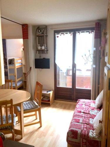 Cette chambre comprend un lit, une table et une porte. dans l'établissement Résidence Serac - SER201 - APPARTEMENT 4 PERSONNES, SECTEUR 1700M MAE-9164, à Les Prés