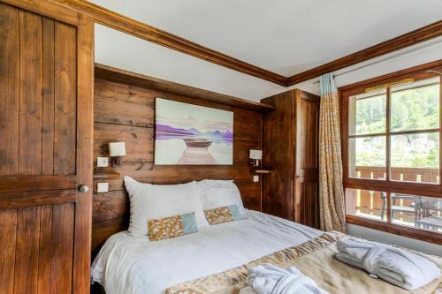 - une chambre avec un lit et un mur en bois dans l'établissement Résidence Les Arcs 1950 Le Village - maeva Home - Appartement 2 pièces 4 personnes - Prestige MAE-1194, à Bourg-Saint-Maurice