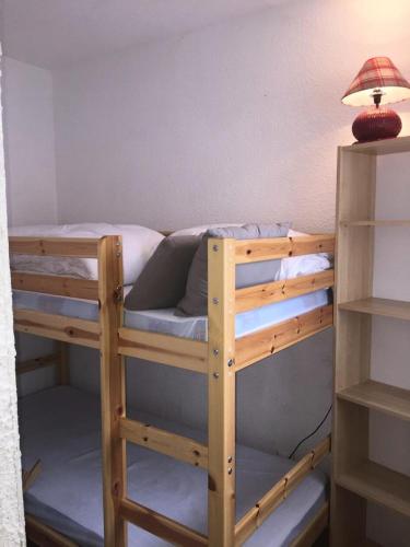 un lit superposé en bois avec une lampe sur une étagère dans l'établissement Résidence Serac - SER201 - APPARTEMENT 4 PERSONNES, SECTEUR 1700M MAE-9164, à Les Prés