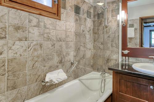 une salle de bain avec une baignoire et un lavabo dans l'établissement Résidence Les Arcs 1950 Le Village - maeva Home - Appartement 2 pièces 4 personnes - Prestige MAE-1194, à Bourg-Saint-Maurice