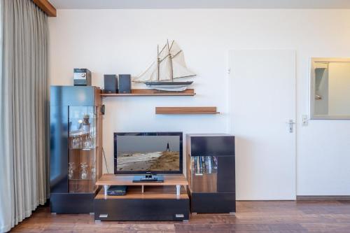 a living room with a tv and a table at Haus Atlantic, FeWo 605 in Döse