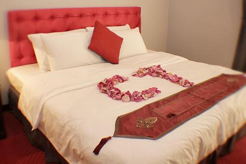 a bed with pink flowers on top of it at Carlton Tower Hotel Kuwait in Kuwait