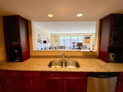 uma cozinha com um lavatório e vista para uma sala de estar em Spacious Waterfront Apt #801 with AC em Halifax