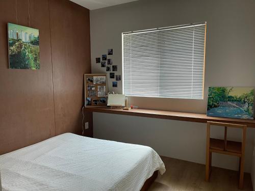 a bedroom with a bed and a desk and a window at Chuncheon Diary Stay in Chuncheon