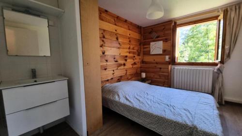 a small bedroom with a bed and a window at Le Chalet - Appartements pour 4 Personnes 174 in Puy-Saint-Vincent