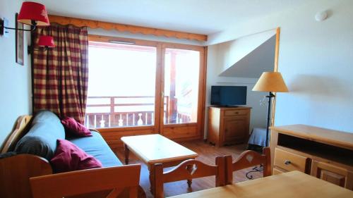 a living room with a blue couch and a window at Résidence Dame Blanche - 2 Pièces pour 6 Personnes 194 in Narreyroux