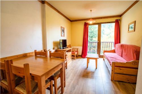 un salon avec une table et un canapé dans l'établissement Chalets Du Thabor - CHALETS DU THABOR - CTHAA9 MAE-3196, à Modane
