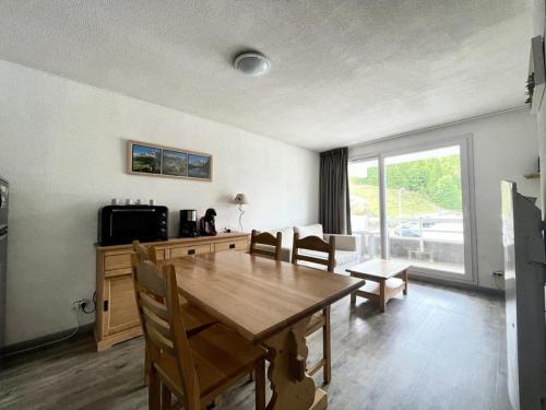 une salle à manger avec une table et des chaises en bois dans l'établissement Résidence Sun Vallee - SUNV217 - Appartement 6 personnes avec terrasse MAE-8034, à Les Prés