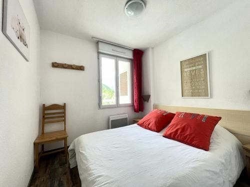 une chambre avec un lit avec des oreillers rouges et une fenêtre dans l'établissement Résidence Sun Vallee - SUNV217 - Appartement 6 personnes avec terrasse MAE-8034, à Les Prés