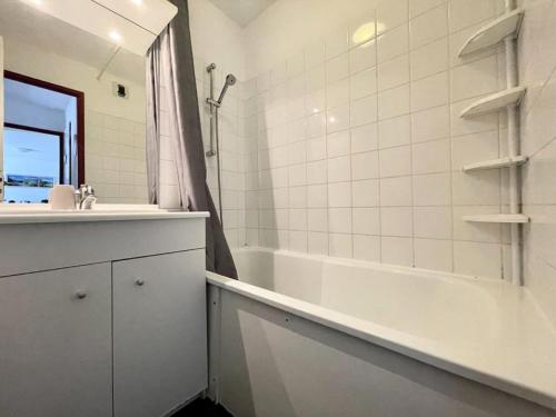 La salle de bains est pourvue d'une baignoire blanche, d'un lavabo et d'une baignoire. dans l'établissement Résidence Sun Vallee - SUNV217 - Appartement 6 personnes avec terrasse MAE-8034, à Les Prés