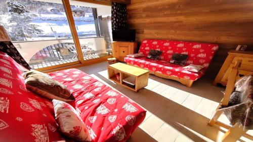 a living room with a red couch and a table at Résidence Saint Roch - Studio pour 4 Personnes 044 in Puy-Saint-Vincent