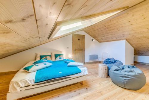 une chambre avec un grand lit avec des oreillers bleus dans l'établissement Résidence Les Balcons EtoilÉs - Appartement 4 au pied des pistes MAE-3253, à Champagny-en-Vanoise