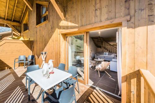 une maison en bois avec une table et des chaises sur une terrasse dans l'établissement Résidence Les Balcons EtoilÉs - Appartement 4 au pied des pistes MAE-3253, à Champagny-en-Vanoise