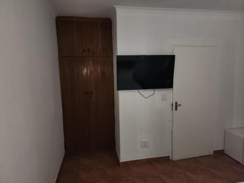 um quarto com uma televisão e um armário com uma porta em Sirwine Hotel, Bar and Restuarant em Windhoek
