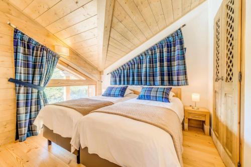 deux lits dans une chambre avec plafonds en bois dans l'établissement Résidence Les Balcons EtoilÉs - Appartement 4 au pied des pistes MAE-3256, à Champagny-en-Vanoise