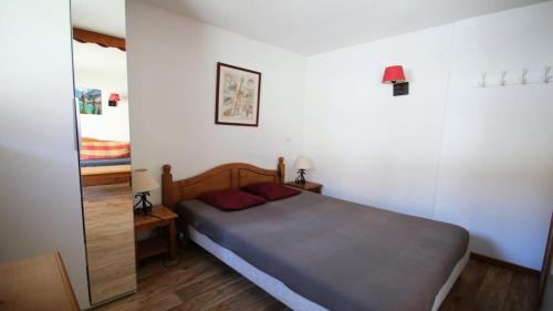 une petite chambre avec un lit et un miroir dans l'établissement Résidence Dame Blanche - DBA121 - APPT 1 CHAMBRE + CABINE - BALCON - 6 PERSONNES MAE-2384, à Narreyroux