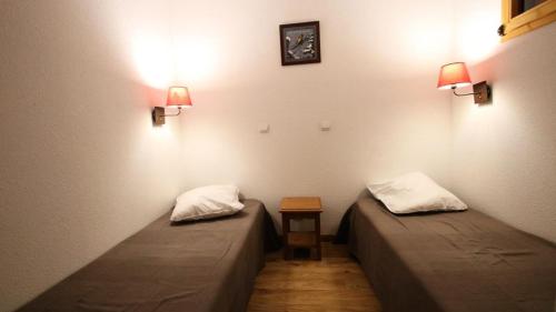 - 2 lits dans une chambre avec une table et 2 lampes dans l'établissement Résidence Dame Blanche - DBA126 - APPT 1 CHAMBRE + CABINE - TERRASSE- 6 PERSONNES MAE-2394, à Narreyroux