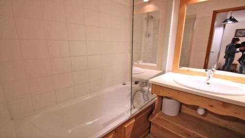 uma casa de banho com uma banheira, um lavatório e um chuveiro em Résidence Dame Blanche - 2 Pièces pour 6 Personnes 394 em Narreyroux