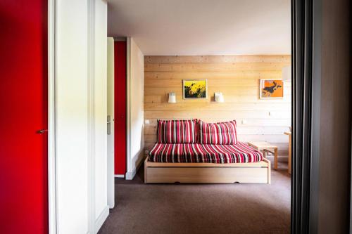 - un salon avec un canapé rouge dans l'établissement Résidence Plagne Lauze - maeva Home - Studio 4 personnes - Budget MAE-6804, à Mâcot La Plagne