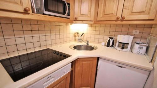 une petite cuisine avec un évier et un micro-ondes dans l'établissement Résidence Dame Blanche - DBA127 - APPT 1 CHAMBRE + CABINE - BALCON - 6 PERSONNES MAE-2404, à Narreyroux