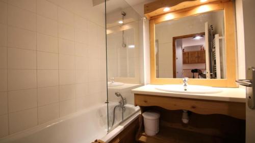 une salle de bain avec une baignoire, un lavabo et un miroir dans l'établissement Résidence Dame Blanche - 2 Pièces pour 6 Personnes 364, à Narreyroux