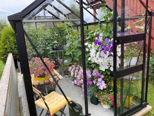 a greenhouse with a bench and flowers in it at Spacious house near city centre in Trondheim