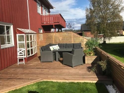 a patio with a couch on a wooden deck at Spacious house near city centre in Trondheim