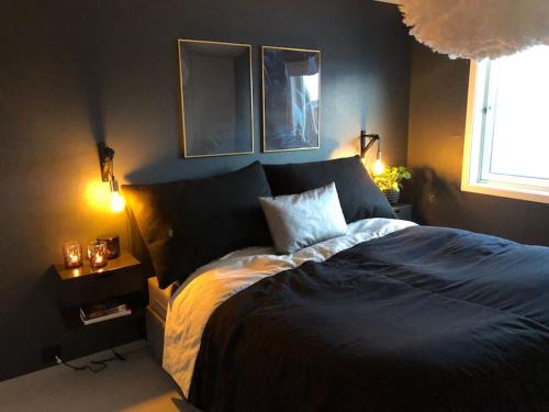 a bedroom with a bed and two lamps and a window at Spacious house near city centre - WSC 2025! in Trondheim