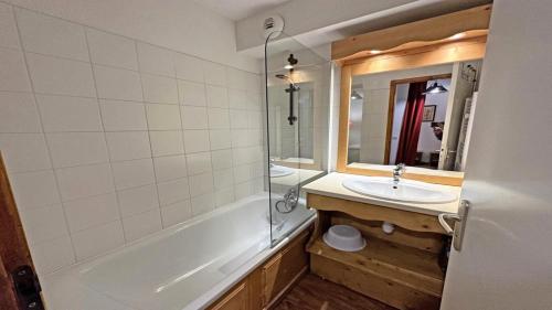 une salle de bain avec une baignoire, un lavabo et un miroir dans l'établissement Résidence Dame Blanche - DBA208 - APPT 1 CHAMBRE + CABINE - BALCON - 6 PERSONNES MAE-2434, à Narreyroux