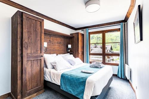 une chambre avec un grand lit et une fenêtre dans l'établissement Résidence Les Arcs 1950 Le Village - maeva Home - Appartement 3 pièces 6 personnes - Prestige MAE-8924, à Bourg-Saint-Maurice
