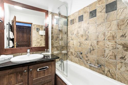 une salle de bain avec un lavabo, une baignoire et une douche dans l'établissement Résidence Les Arcs 1950 Le Village - maeva Home - Appartement 3 pièces 6 personnes - Prestige MAE-8924, à Bourg-Saint-Maurice