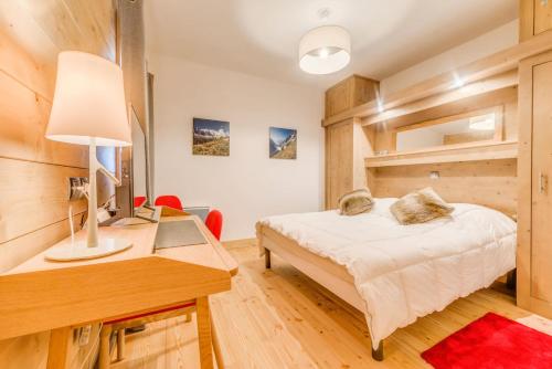une chambre avec un lit et un bureau avec un ordinateur dans l'établissement Résidence Les Balcons EtoilÉs - Appartement 4 au pied des pistes MAE-3269, à Champagny-en-Vanoise