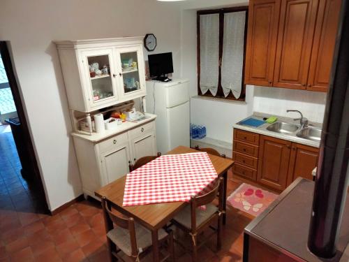 una cocina con una mesa con un mantel a cuadros rojo y blanco en La casa della Nonna, en Codiponte