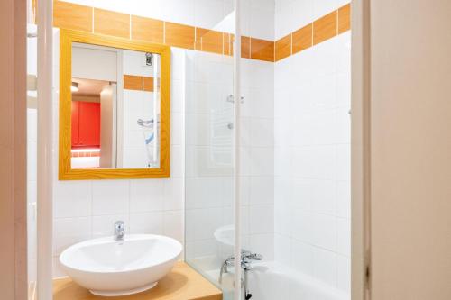 une salle de bain blanche avec un lavabo et un miroir dans l'établissement Résidence Plagne Lauze - maeva Home - Studio 4 personnes - Sélection MAE-3734, à Mâcot La Plagne