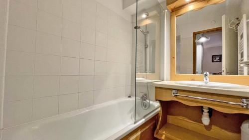 une salle de bain avec une baignoire, un lavabo et un miroir dans l'établissement Résidence Dame Blanche - DBA122 – APPT 1 CHAMBRE + CABINE - BALCON - 6 PERSONNES MAE-2634, à Narreyroux