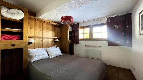 a small bedroom with a bed and a window at Résidence Dame Blanche - Chalets pour 8 Personnes 644 in Narreyroux