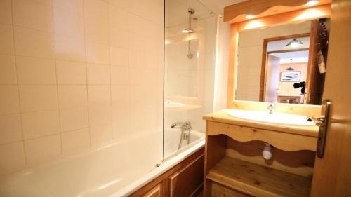 a bathroom with a sink and a tub and a mirror at Résidence Dame Blanche - Chalets pour 8 Personnes 644 in Narreyroux