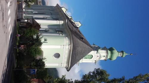 a tall white building with a roof at Casa Monteggia in Dobbiaco