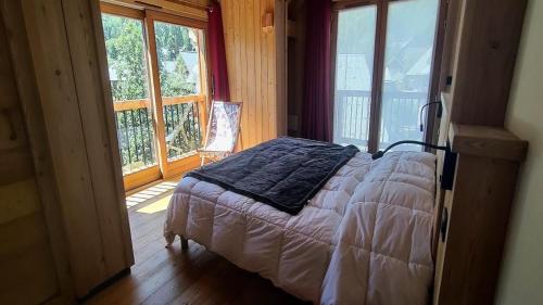 una camera con un letto in una stanza con finestre di Chalet - Chalets pour 13 Personnes 594 a Puy-Saint-Vincent