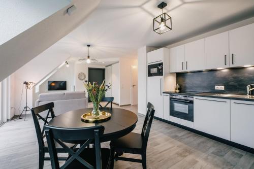 a kitchen and dining room with a table and chairs at Résidence Les Charmes in Boofzheim
