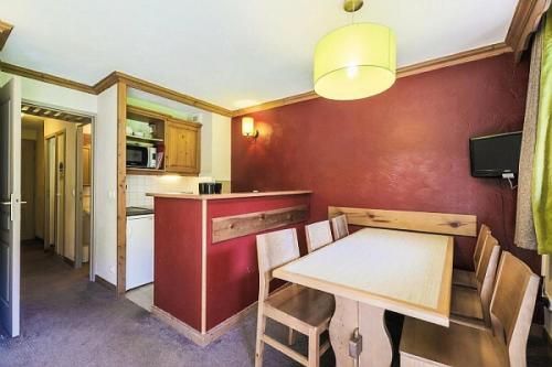 une cuisine avec une table et des chaises dans une pièce dans l'établissement Quartier La Forêt - maeva Home - Appartement 2 pièces 6 personnes - Sélection MAE-1634, à Valmorel
