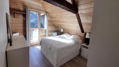 a bedroom with a bed in a wooden cabin at Résidence Le Refuge De Lulu-vallouise-pelvoux - Chalets pour 16 Personnes 564 in Pelvoux
