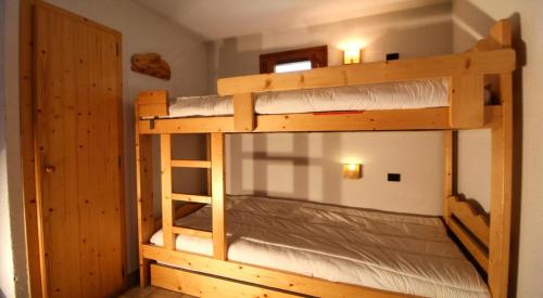 two bunk beds in a room with a door at Résidence Le Chardonnet - Studio pour 4 Personnes 193282 in Champagny-en-Vanoise