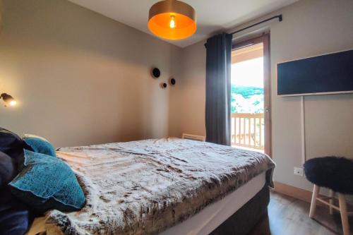 a bedroom with a bed and a large window at CHALET LUMI - Chalet CHALET LAURENTIDE pour 6 Personnes 464 in Les Avanchers